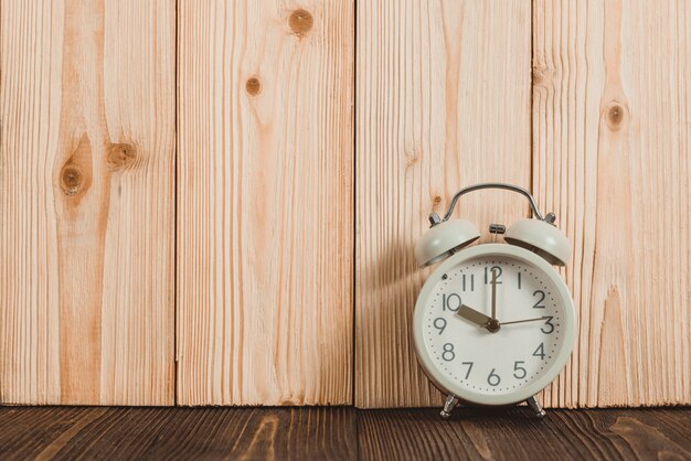 木製のテーブル、時間の概念にレトロなビンテージの目覚まし時計。