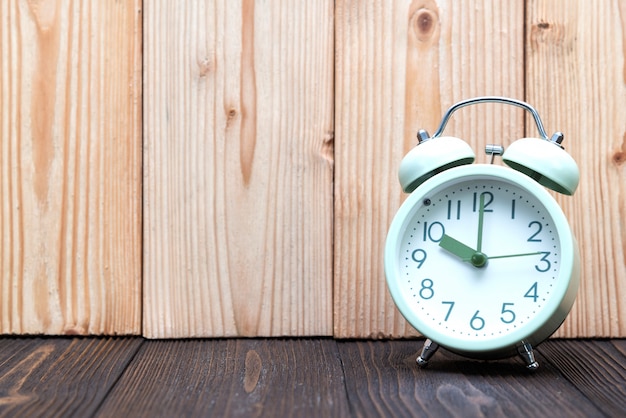 Retro vintage alarm clock on wood table.