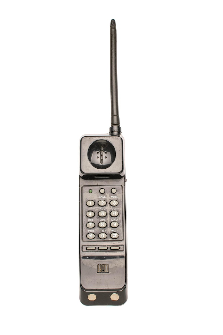 Photo retro vintage brick cell phone with antenna and keypad iconic 80s technology