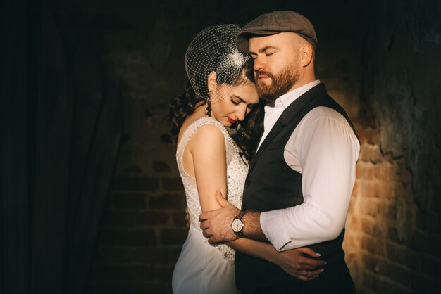 Retro wedding couple inside the old church on the ray of sun