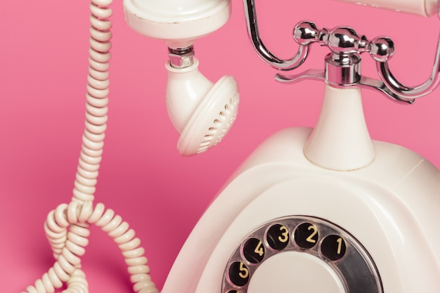 Retro white telephone on pink background