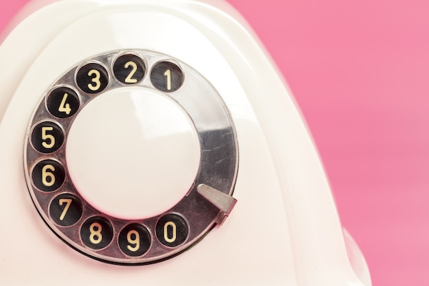 Retro white telephone on pink background