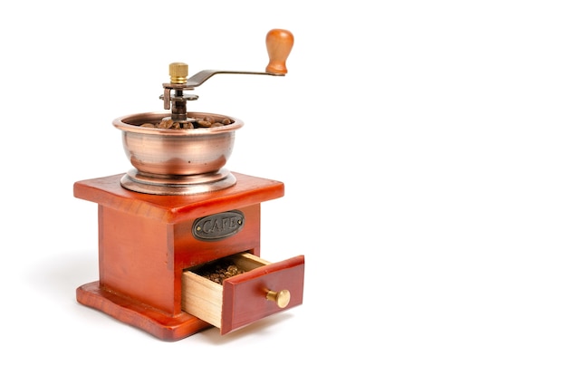 Photo retro wooden coffee grinder on white background with coffee beans.