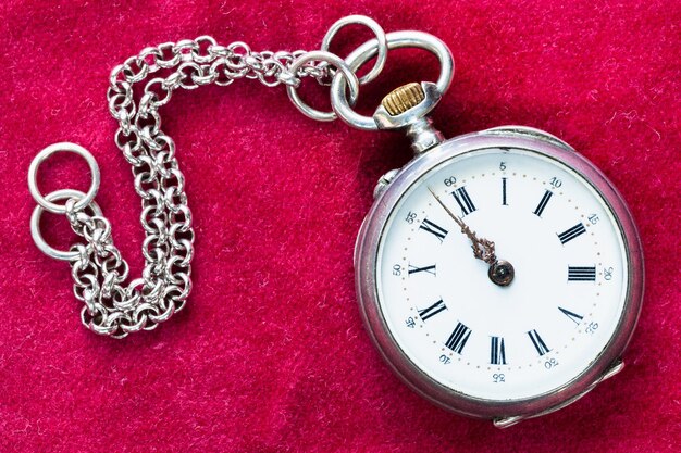 Retro zilveren zakhorloge met ketting op rood fluweel