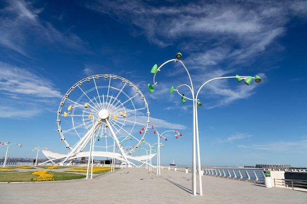 Reus reuzenrad aan zee met de skyline van de stad op de achtergrond tegen de blauwe hemel Bakoe Azerbeidzjan