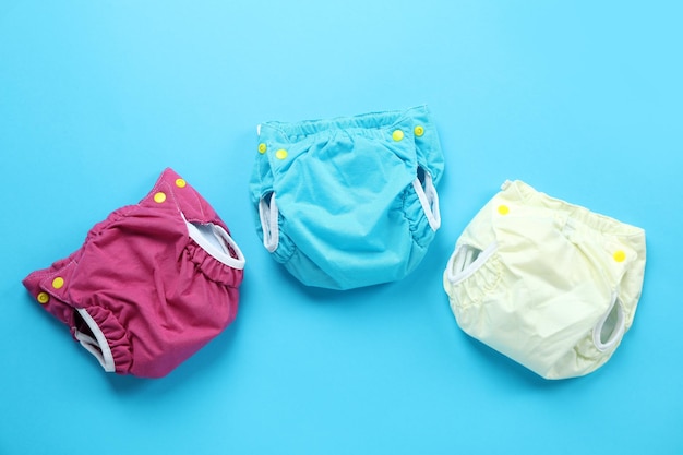 Reusable diapers on blue background, close up