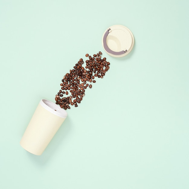 reusable eco coffee cup with roasted coffee beans zero waste concept flat lay