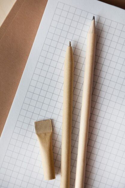 Reusable eco-friendly craft paper pen and pencil on the notebook. Writing ballpoint pen, environmental protection, ecology, natural materials, recycling concept