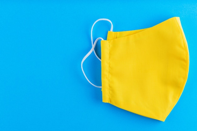 Reusable face mask made from yellow cotton.