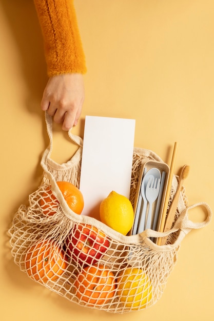 Foto borsa a rete riutilizzabile piena di frutta e utensili da viaggio ecologici