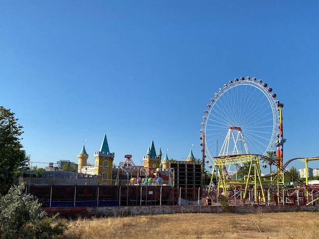 Reuzenrad in pretpark met blauwe hemelachtergrond