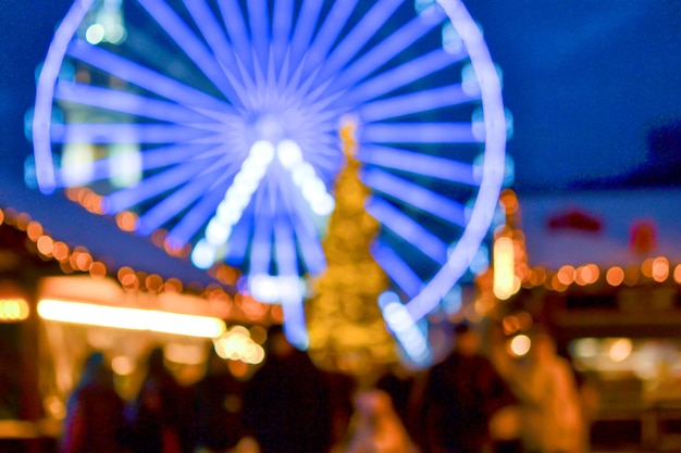 Reuzenrad versierd met blauwe verlichting Kerstboom zwarte silhouetten