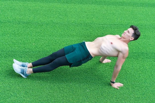 Reverse plank helps strengthen lower back, man exercising outdoors.