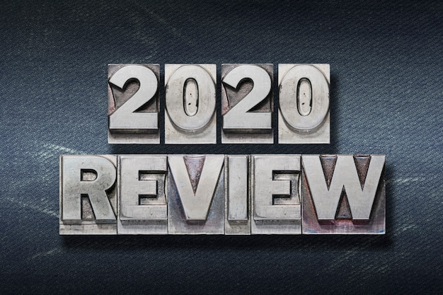 Review 2020 phrase made from metallic letterpress on dark jeans background