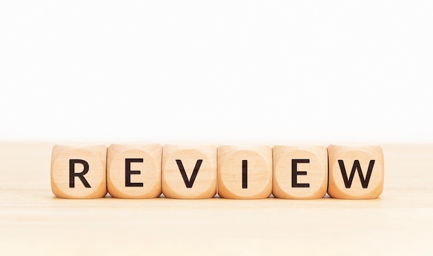 Review word on wooden blocks on white background Copy space