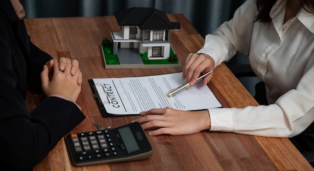 Reviewing house loan contract with agent using calculator Enthusiastic