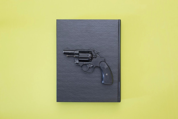 Photo revolver and black book on a colored background