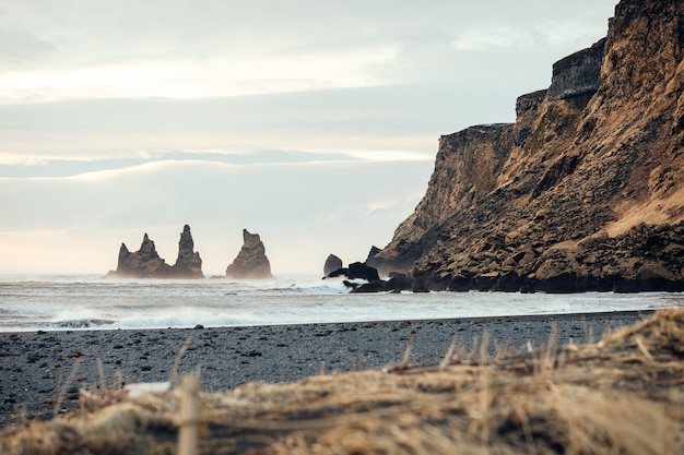 Foto reynisdrangar-gezichtspunt over black sand beach in vik, ijsland