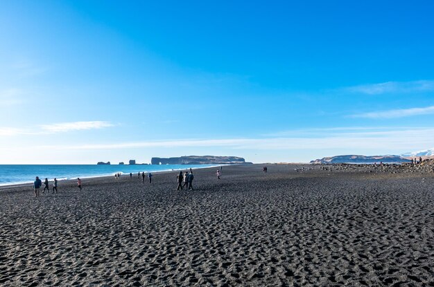 Reynisfjara black sand beach is landmark of Vik town in Iceland surrounded with basalt mountains