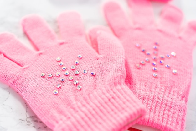 Rhinestone pink kids gloves with snowflake shapes.