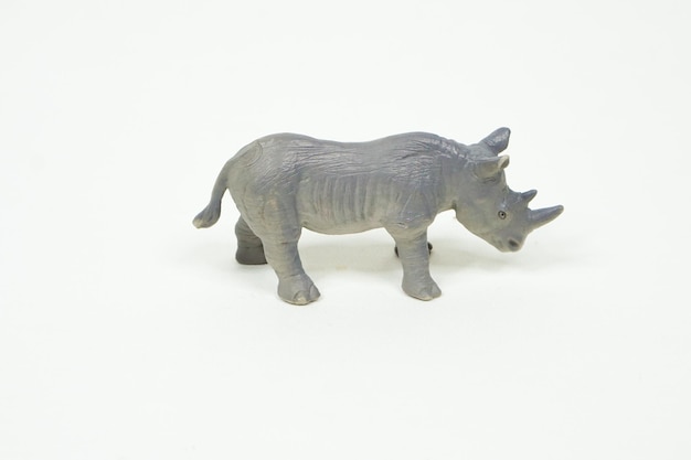 Rhino mini figure isolated on white background. Plastic animal toys.