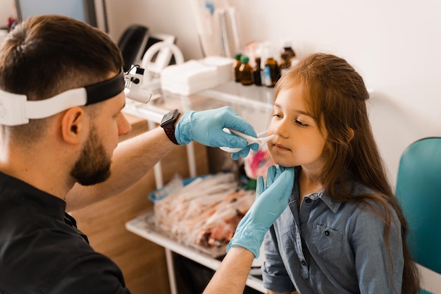 Rhinoscopy of child nose Consultation with doctor Children otolaryngologist examines child nose before procedure of endoscopy of nose