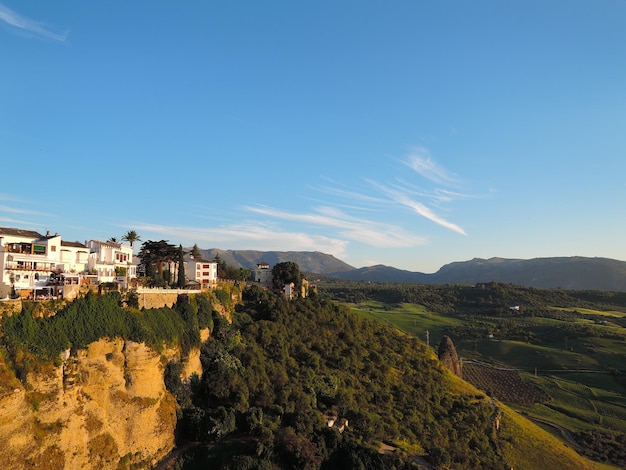 Rhoda. Spanje. Andalusië. Oude stad. Puento nuevo. Zonsondergang over groene heuvels en witte huizen. Ronda stadsbeeld in de zomer