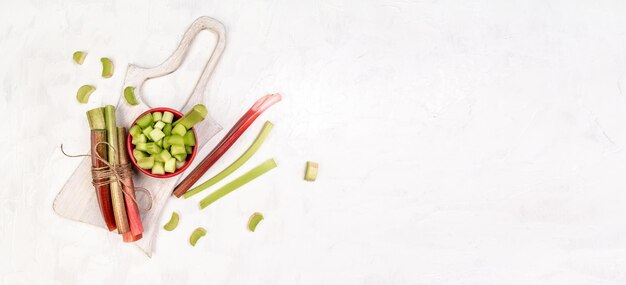 Rhubarb stalks on a board white background banner catering menu recipe place for text top view