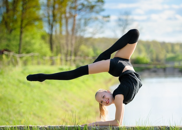 Rhythmic gymnast girl exercising with ribbon outdoor