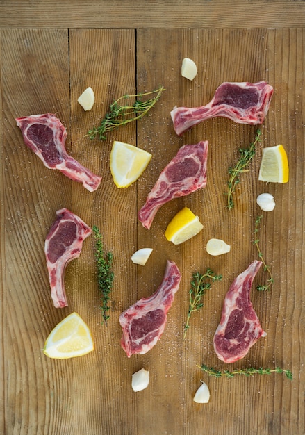 Rib chops, herbs and lemon against wooden table