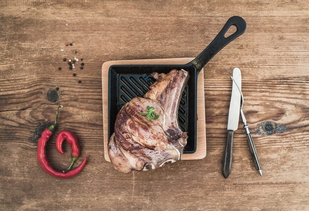 Rib eye steak met gekookt vlees, kruiden, rode chili, rozemarijn en vintage zilverwerk incookinf pan