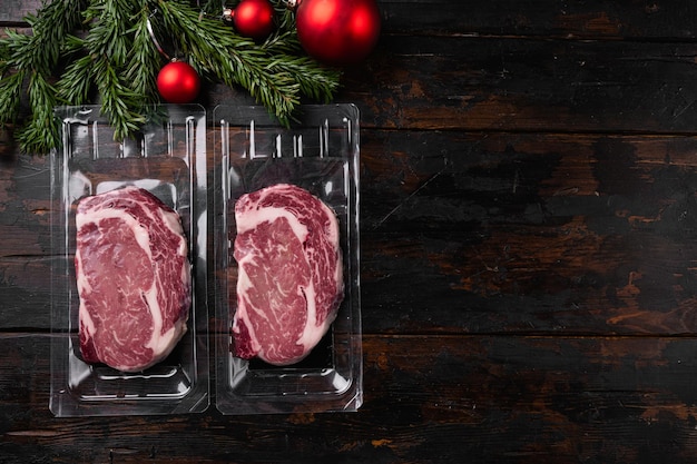 Rib eye steak pack newyear set on old dark wooden table\
background top view flat lay