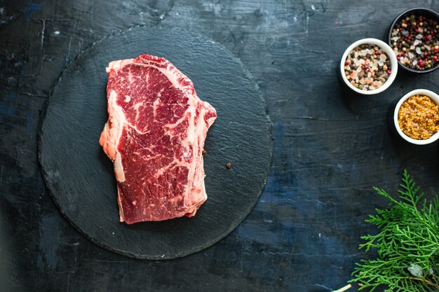 Rib-eye steak with spices on a board