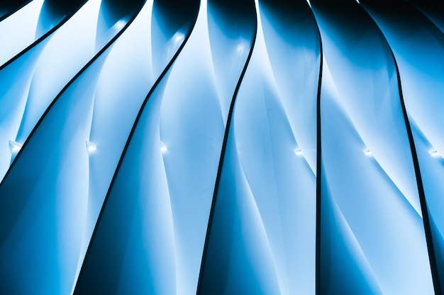 Ribbed wall with wavy stripes on it and blue backlighting in the middle