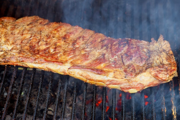 Ribben die op barbecuegrill koken voor voedselachtergrond met barbecue