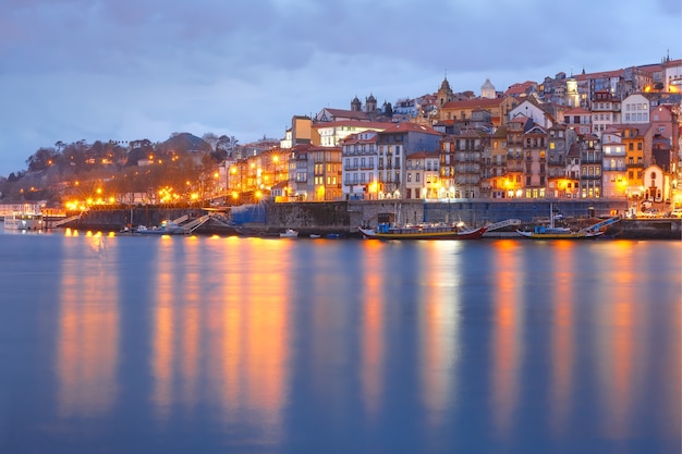 Ribeira e la città vecchia di porto con riflessi speculari nel fiume douro durante l'ora blu serale, portogallo, portogallo.