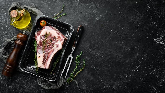 Ribeye beef steak in vacuum packaging market top view flat lay\
top view on black stone cutting table