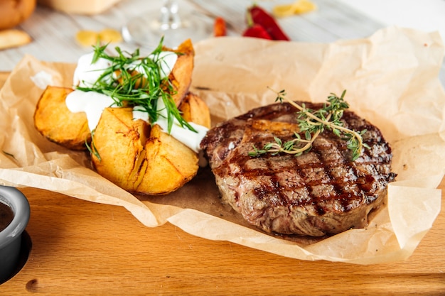 Ribeye beef steak with baked potatoes  sour cream