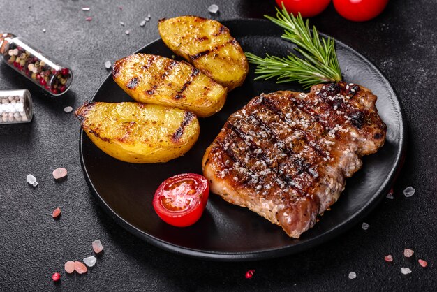 Ribeye steak met aardappelen, uien en kerstomaatjes. Sappige biefstuk met gearomatiseerde boter