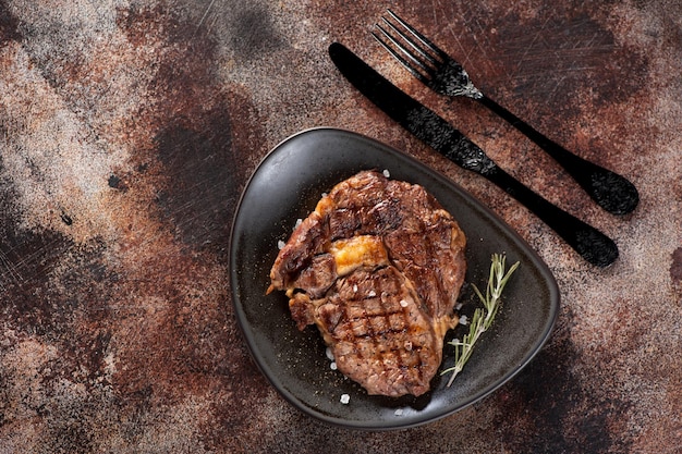 Ribeye Steak op een roestig getextureerd bovenaanzicht als achtergrond