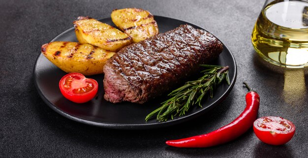 감자, 양파, 체리 토마토와 Ribeye 스테이크. 맛 버터와 육즙이 스테이크