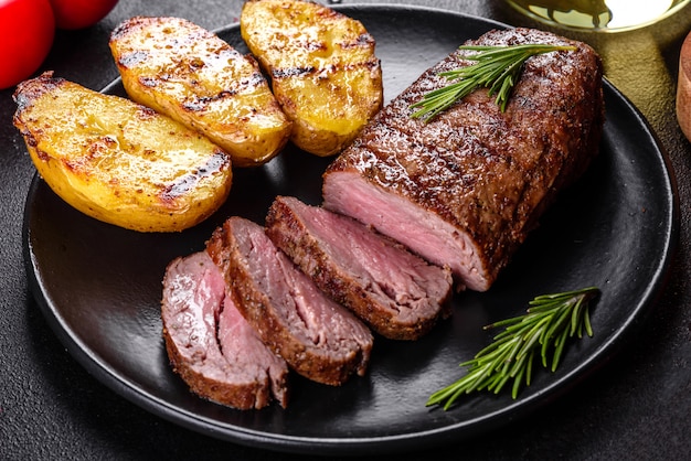 Ribeye steak with potatoes, onions and cherry tomatoes. Juicy steak with flavored butter