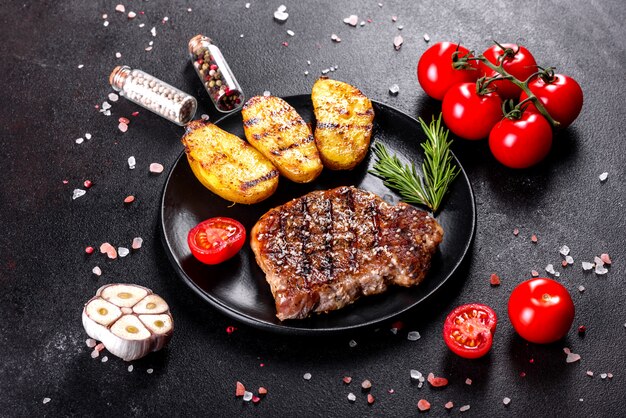 Ribeye steak with potatoes, onions and cherry tomatoes. Juicy steak with flavored butter
