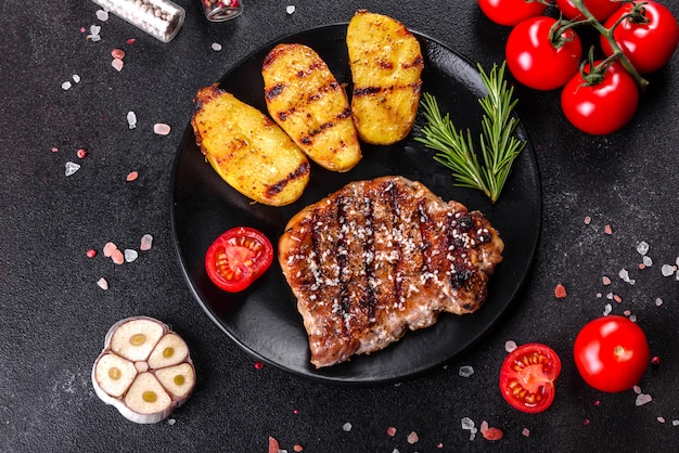 Ribeye steak with potatoes, onions and cherry tomatoes. Juicy steak with flavored butter