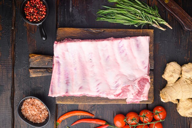 Ribs cooking with sauce marinade ingredient set, on old dark wooden table, top view flat lay