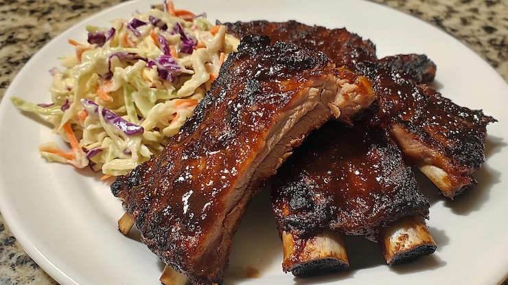 Photo ribs with barbecue sauce and coleslaw on a white plate