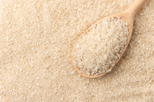 Rice background with wooden spoon.