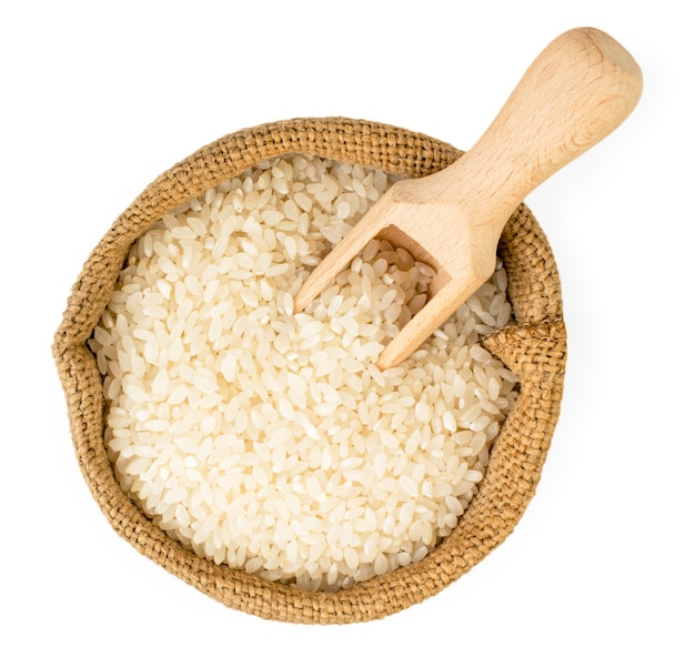 Rice in a bag and a wooden spoon on a white background