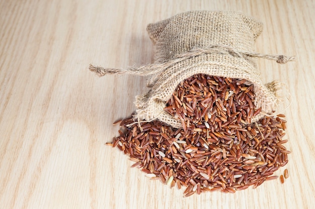 Rice berry in a sack on a wooden background