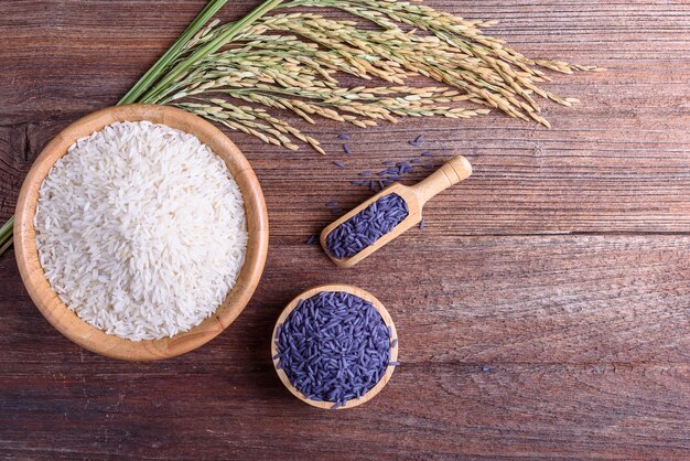 Rice berry and unmilled rice on wooden background